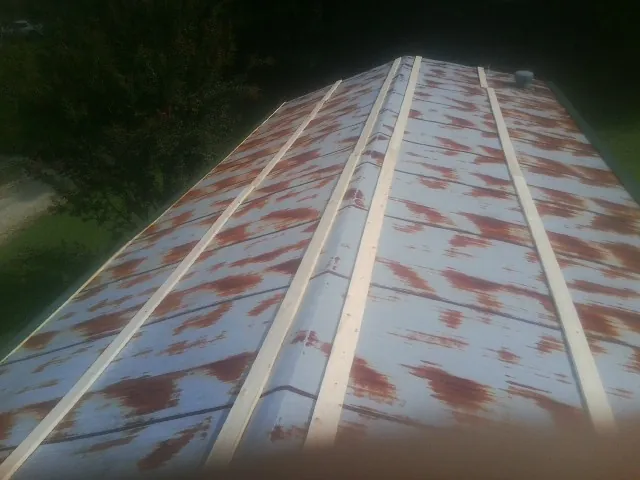 Rusted metal roof panels with new wood purlins before replacement — Storm Damage Roof Repair in Chevy Chase by Roofing Brothers