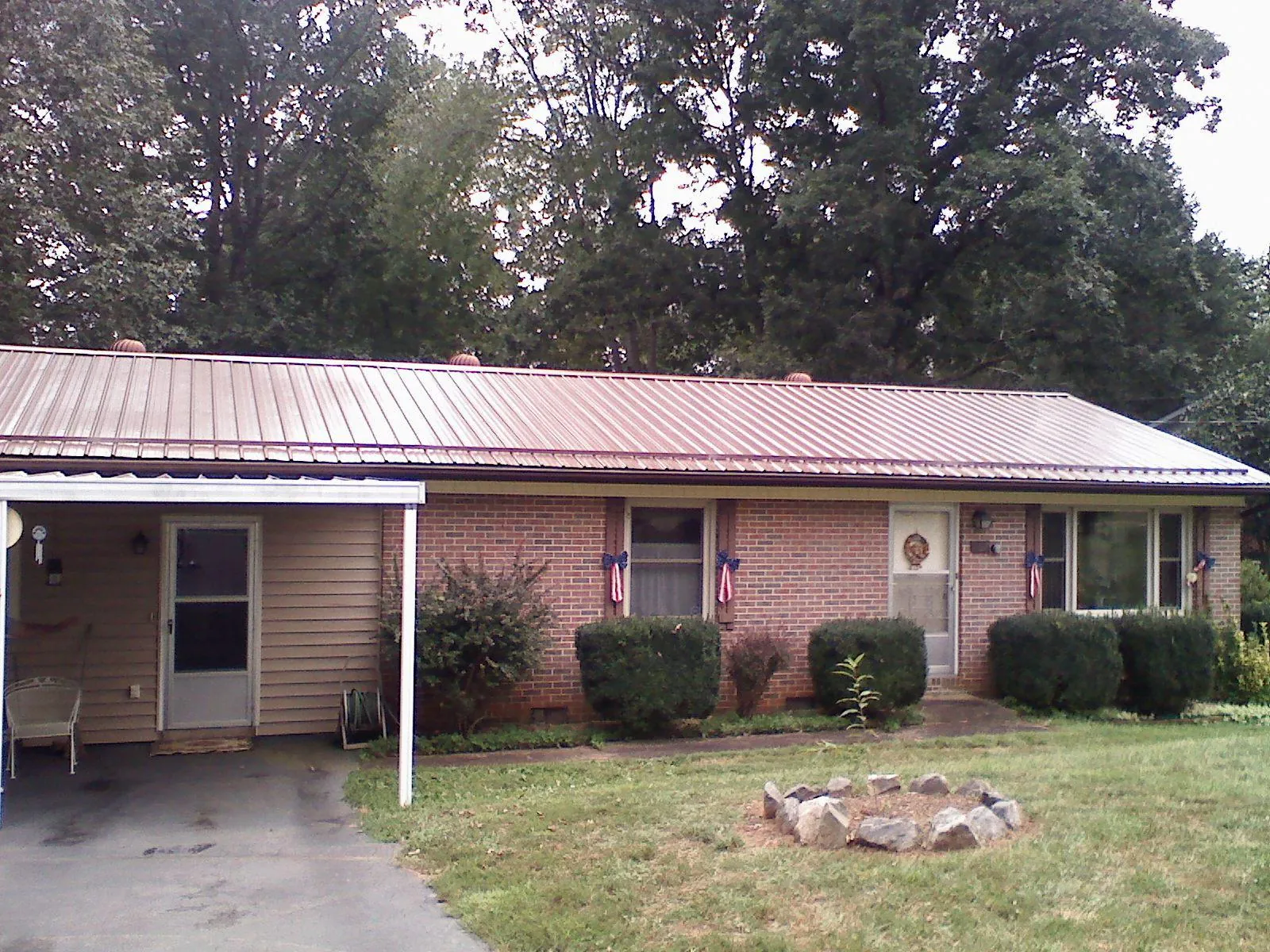 Bronze metal roof and carport on a brick ranch home — Roof Repair work by our crew in Chevy Chase